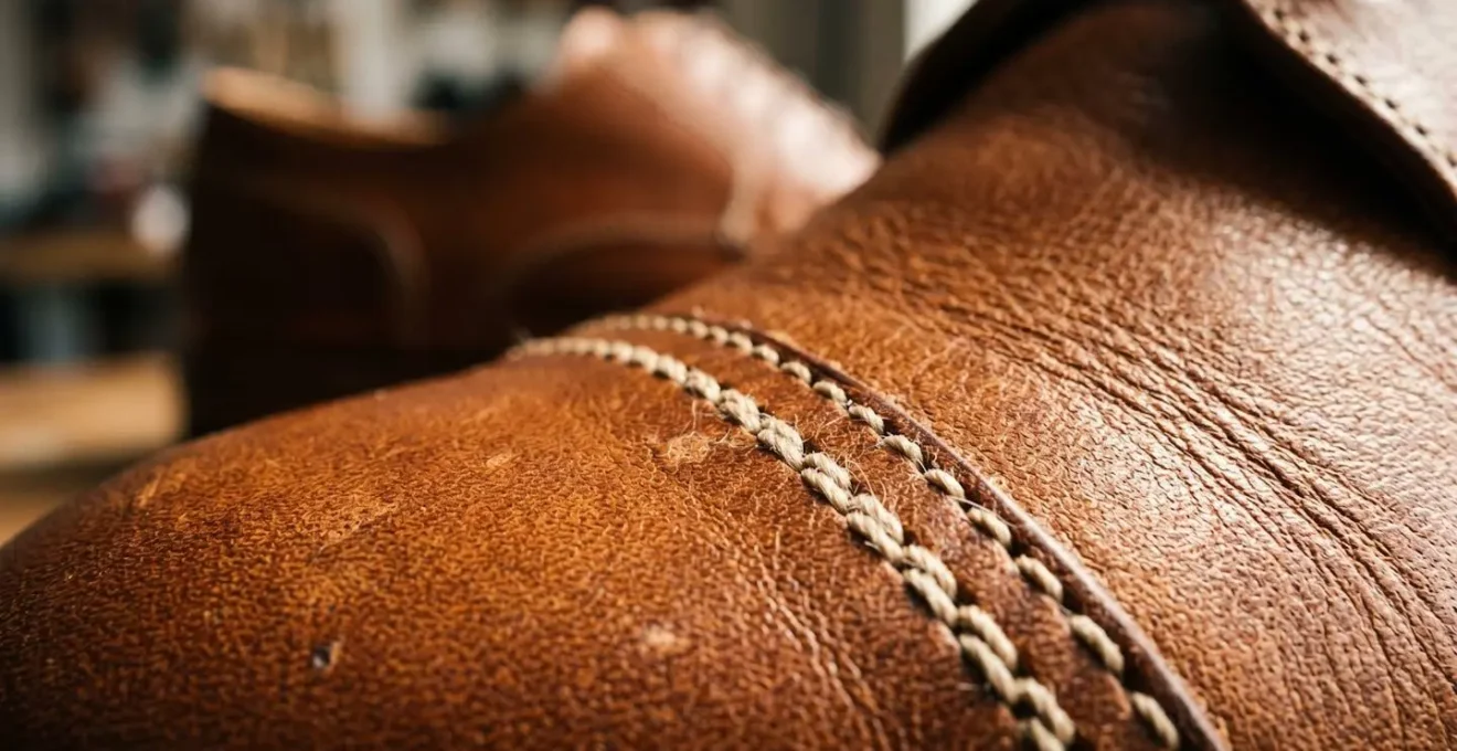 Gros plan macro sur la texture d'un cuir pleine fleur de chaussure avec détails de couture et grain naturel