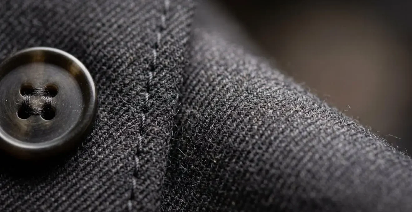 Composition macro mettant en valeur les textures et matières d'un ensemble pantalon professionnel féminin